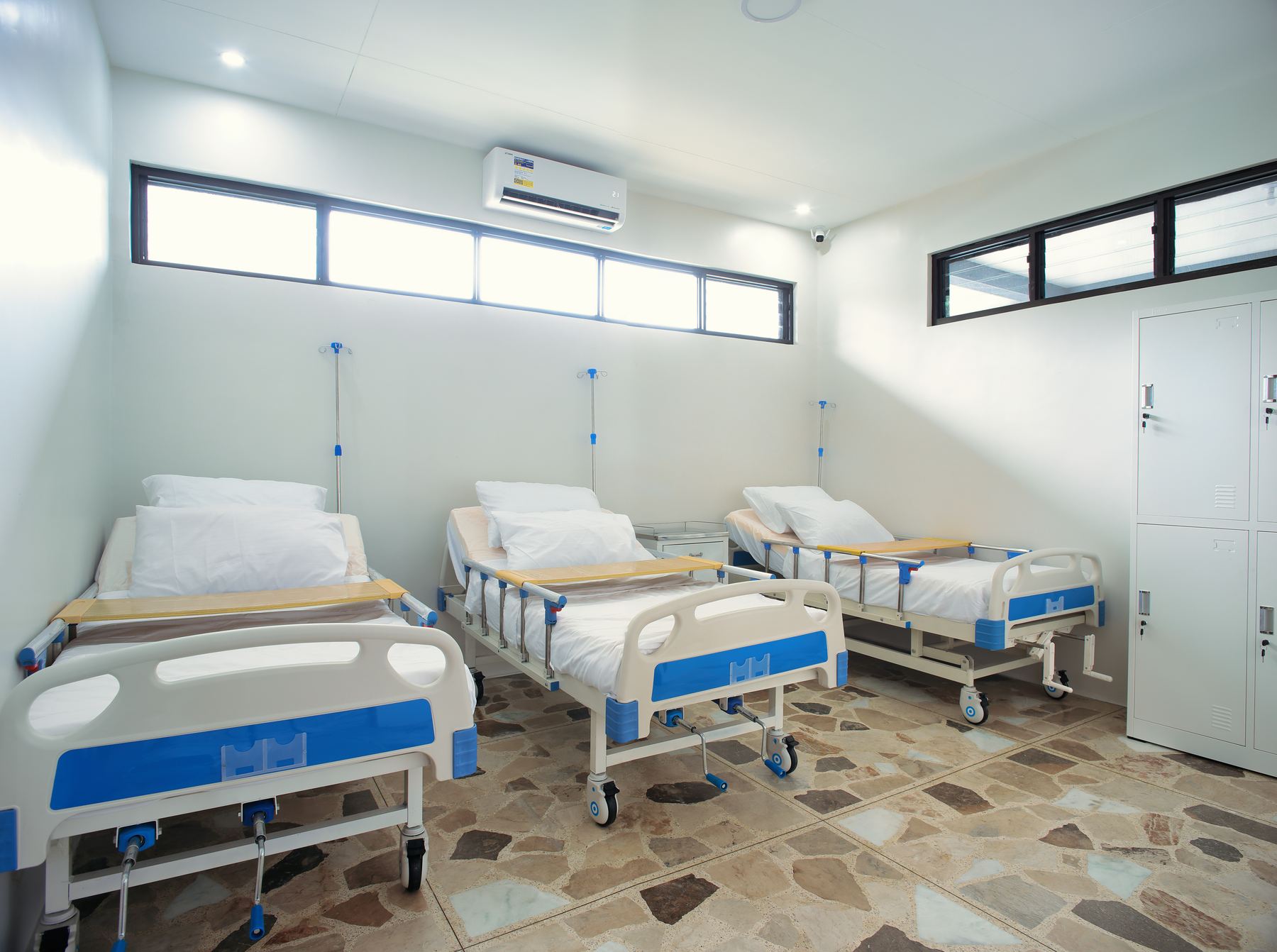 Bright shared room with three hospital-grade adjustable beds